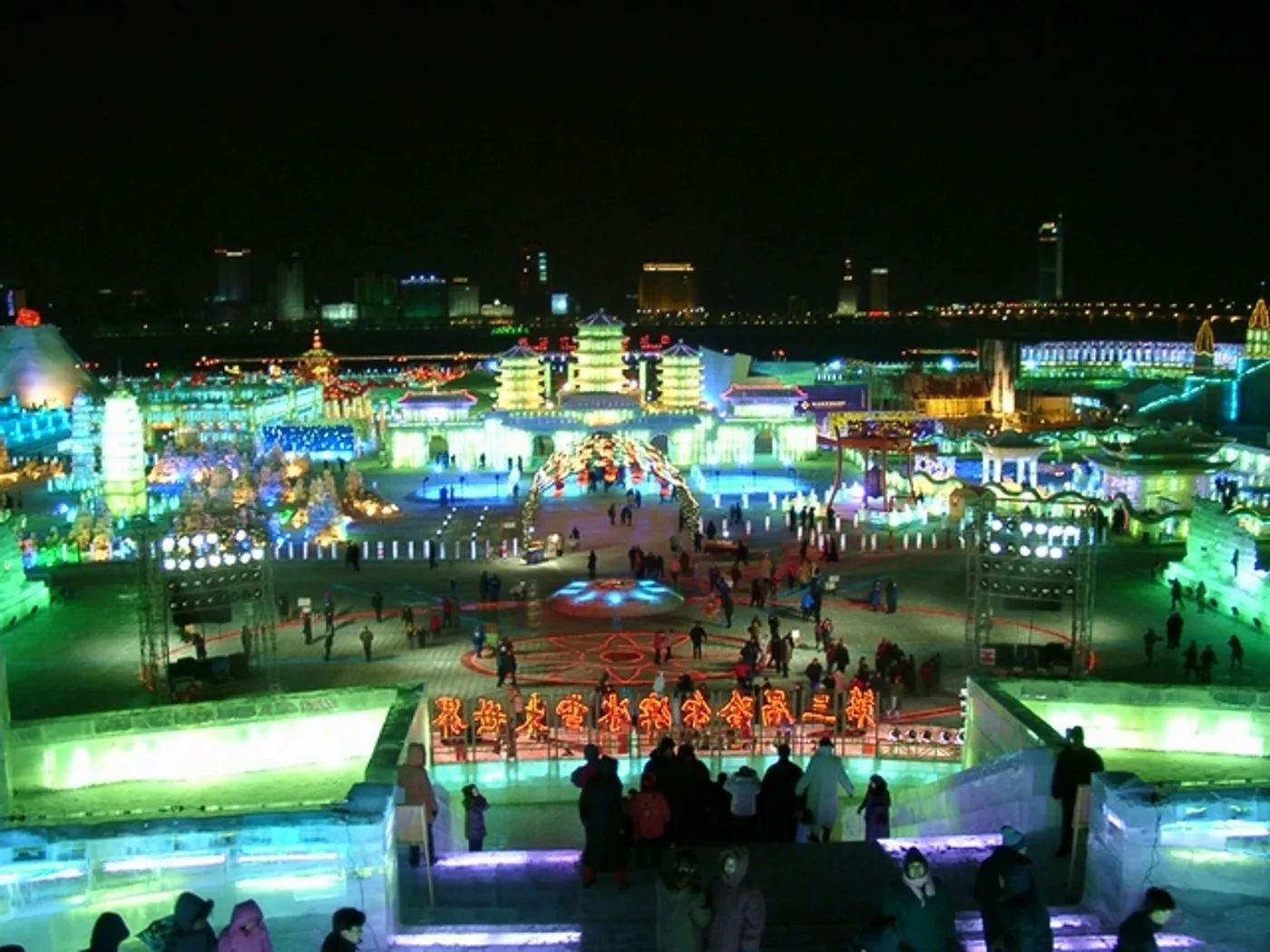 Wide view of the Ice Snow World park in Harbin with ice buildings at dusk